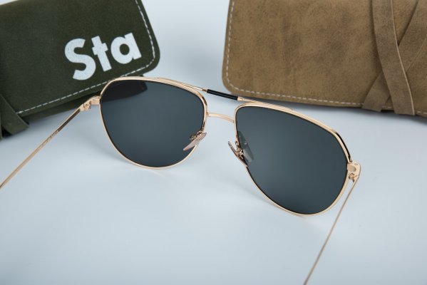 aviator style sunglasses on a white table with carrying case beside them
